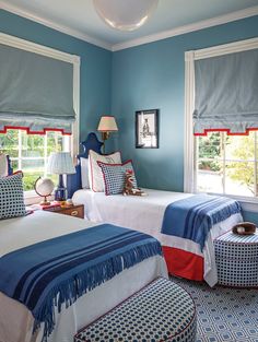 two beds in a bedroom with blue walls