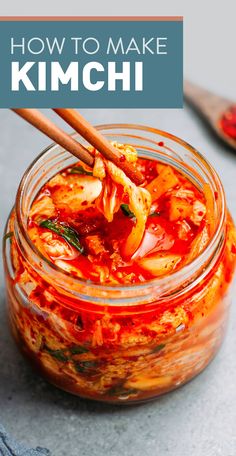 a glass jar filled with kimchi sauce and chopsticks sticking out of it