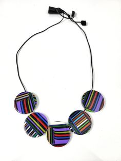 This necklace is part of the Pop Art line and is called Pier. The Pop Art line was created by Sobral to represent the passage of Modernity into Post Modernity in the Western culture. This necklace is the Night version which features a vibrant stripe motif on a black background. There are 5 circle beads and they measure in diameter 1.375". The opposite side of each piece does have some slight variations making this reversible. The strand is currently 17.5" but is adjustable by sliding the toggle. Adjustable Round Necklace With Artistic Design, Adjustable Multicolor Artistic Design Necklaces, Artsy Multicolor Round Bead Jewelry, Round Adjustable Artistic Design Necklace, Unique Hand Painted Round Necklaces, Artistic Multicolor Round Bead Jewelry, Artsy Multicolor Necklaces With Artistic Design, Adjustable Hand Painted Round Necklace, Adjustable Multicolor Artistic Necklaces