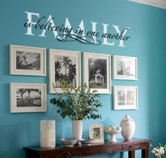 a living room with blue walls and pictures hanging on the wall, along with a coffee table