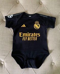 a black baby bodysuit with the words emiratess fly better on it