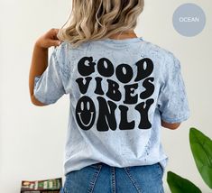 "This \"Good Vibes Only\" Tee is just what you need to add some fun and whim into your wardrobe! Crafted with super soft, lightweight fabric and dyed in a stunning tie-dye pattern, this shirt will have you looking stylish and feeling comfortable all day long. The vibrant colors are sure to give your wardrobe a much needed boost and make sure you stand out from the crowd. To top it off, this Good Vibes Only Shirt features a super cute smiley face on the front and 'Good Vibes Only' on the back - p Acid Wash Slogan Top With Relaxed Fit, Relaxed Fit Acid Wash Tops With Funny Print, Acid Wash Relaxed Fit Slogan Top, Relaxed Fit Acid Wash Slogan Top, Relaxed Fit Acid Wash Top With Slogan, Fun Acid Wash Tops With Letter Print, Trendy Blue Top With Funny Text, Trendy Acid Wash Tops With Relaxed Fit, Unisex Trendy Tops With Funny Text