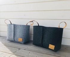 two black and grey bags sitting on top of a wooden floor next to each other