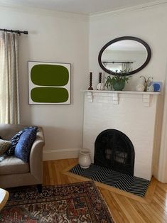 a living room filled with furniture and a fire place next to a window on top of a hard wood floor