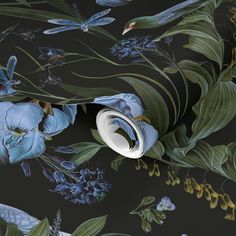 the wallpaper has blue flowers and green leaves on it, along with a black background