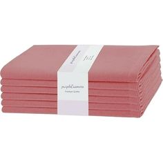 six pink folded napkins with white ribbon