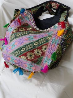 Patchwork, embroidery and sequins women's tote bag. A colourful ethnic shoulder bag from India for women. Unique, classy day or evening hand bag. Take patches of colourful cloth. Add interesting embroidery of sequins and stones and beads. Add some more colourful stitches with contrasting colour thread. Mix and match the patches and hand stitch them with a colourful beading. Add handles. Voila! You have a tote bag that is so unique that there just cannot be another one such, anywhere in the unive Festive Bollywood Shoulder Bag Handmade, Bollywood Style Shoulder Bag For Festivals, Bollywood Style Festive Shoulder Bag With Handwork, Bollywood Style Festive Shoulder Bag, Embroidered Shoulder Bag For Festivals, Bollywood Style Multicolor Festive Bags, Bollywood Style Festival Bags, Multicolor Embroidery Hobo Bag For Festivals, Bohemian Multicolor Bags With Zari Work