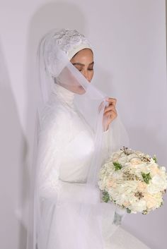 a woman wearing a veil and holding a bouquet