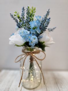 blue and white flowers in a mason jar with twine bow tied around the top