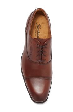 The Florsheim Sorrello Cap Toe Oxford features a modern, tapered toe, and rich burnished finish. Featuring breathable, full leather uppers, breathable suedetec linings, a fully cushioned footbed, and flexible rubber sole. Lace-up vamp Leather upper, rubber sole Imported Brown Derby Shoes With Branded Insole And Cap Toe, Fitted Brown Oxfords With Leather Lining, Classic Brown Snip Toe Oxfords, Fitted Leather Derby For Semi-formal Occasions, Fitted Leather Derby Shoes For Semi-formal Occasions, Semi-formal Fitted Leather Derby Shoes, Fitted Brown Oxfords With Leather Footbed, Fitted Cognac Leather Oxfords, Classic Fitted Brown Derby