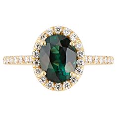 Eye Catching Oval Shaped Green Tourmaline set in a sparkling halo of diamonds in a high polish 18k Yellow Gold Ring. This stunning tourmaline was hand selected for its brilliance, clarity, and attractive bluish green hues. Handset in a delicate setting with a halo of VS quality diamonds, to create a sparkling contrast to the tourmaline hues. Green Tourmaline is believed to promote healing, harmony, and prosperity. Tourmaline has a hardness of 7 to 7.5 on Mohs Scale, so whilst it durable enough for everyday wear it is not as hard as a Diamond or Sapphire and can scratch if abused. Size 6 - can be resized 5.5 -6.5. Detailed Information: Green Tourmaline: 1.46 ctw Primary Stone Size: 8x6 Diamond: .42ctw Secondary Stone Size: 1.25mm (42) Approx. Shank Base Thickness:1.5 mm Antique Cocktail Ring, Sapphire Cocktail Ring, Montana Sapphire Ring, Contemporary Engagement Rings, Green Tourmaline Ring, Green Ring, Diamond Cocktail Rings, Gold Ring Sets, 18k Yellow Gold Ring