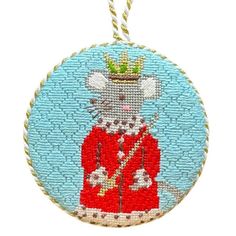 a round ornament with a cat wearing a red coat and crown on it