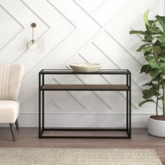 two chairs and a table with a bowl on it in front of a white wall