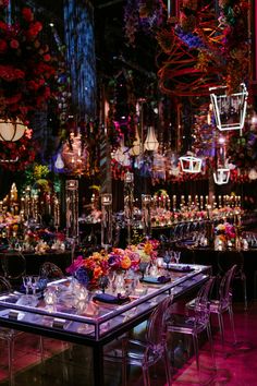 a long table with many chairs around it and lots of lights hanging from the ceiling