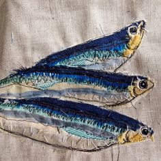 three blue and yellow fish are on a piece of cloth