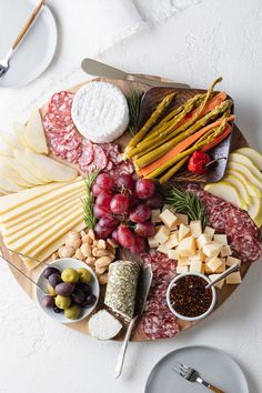 an assortment of cheeses, meats and vegetables on a platter