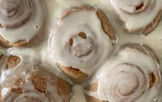 cinnamon rolls covered in icing on top of a pan