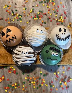 four decorated cupcakes sitting on top of a table