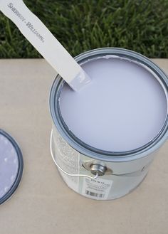 a paint can with a white spatula in it next to some blue plates on the ground