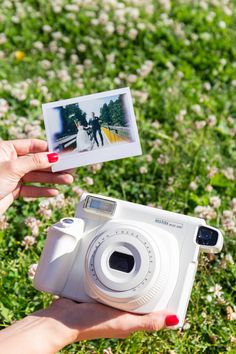 a person holding up a polaroid camera in their hand