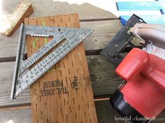 a pair of tools sitting on top of a wooden table next to a ruler and hammer