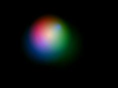 a blurry image of a colorful ball on a black background