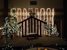 a room with christmas lights on the walls and trees in front of a stage set