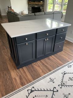 a large kitchen island with white counter tops in a living room next to a couch