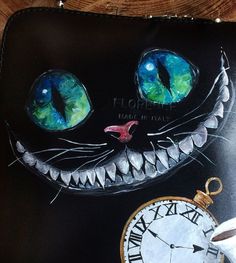 a painting of a cat's face with blue eyes and a clock on the table