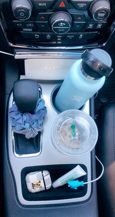 the interior of a car with various items in its place on the console and cup holder