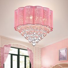 a pink chandelier hanging from the ceiling in a girls'bedroom with pink walls and curtains