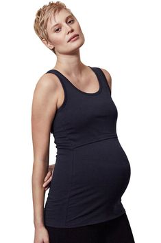 a pregnant woman in black is posing for the camera with her hands on her hips