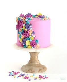 a pink cake with colorful flowers on top and the words cascading floral cake