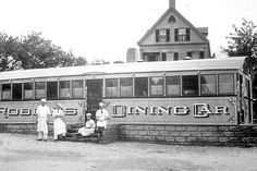 an old black and white photo of people standing in front of a building with a train on it