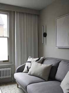 a gray couch sitting next to a window in a living room