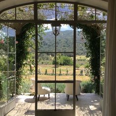 an open glass door leading to a patio with chairs and table in front of it