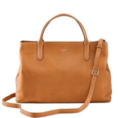 Super-functional and decidedly beautiful, the Caroline Leather Handbag is the ultimate work carryall. Spacious enough to fit a 13" laptop and everything else you need from 9 to 5, this versatile bag goes with everything, making it the perfect addition to your work wardrobe. Swap out the matching leather crossbody strap for one of our many colorful straps to create your own style.    17"w x 6"d x 11.25"h  Leather with a soft linen lining and gold-toned hardware.  See Product Information for more Chic Travel Briefcase With Adjustable Strap, Chic Everyday Laptop Bag With Adjustable Strap, Everyday Rectangular Laptop Bag With Detachable Strap, Everyday Laptop Bag With Adjustable Strap And Double Handle, Chic Satchel Briefcase For Travel, Chic Leather Satchel For Travel, Chic Laptop Shoulder Bag With Leather Handles, Chic Travel Briefcase In Satchel Style, Chic Travel Briefcase Satchel