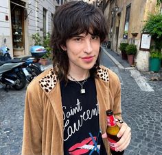 a young man holding a beer in his right hand