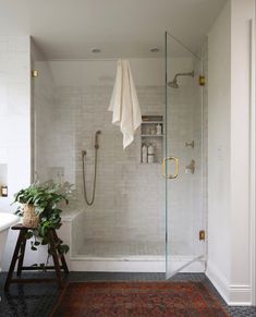 a bathroom with a walk in shower next to a bathtub and sink, along with a rug on the floor