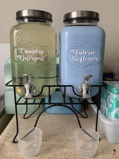 two blue and one green mason jars sitting on top of a counter