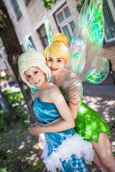 two women dressed as tinkerbells pose for the camera