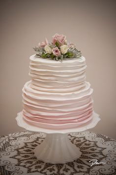 a white cake with pink icing and flowers on top