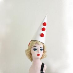 a mannequin wearing a white hat with red polka dots on it's head