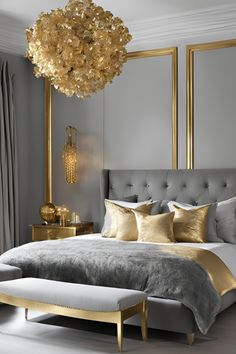 a large bed sitting in a bedroom next to a window with gold accents on it