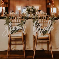 two wooden chairs with greenery on them and the word grow bride spelled in cursive letters