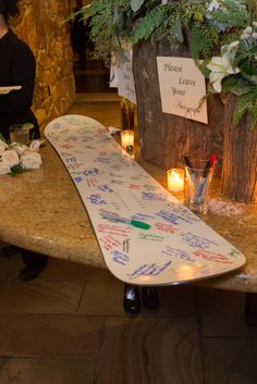 a surfboard sitting on top of a table next to candles