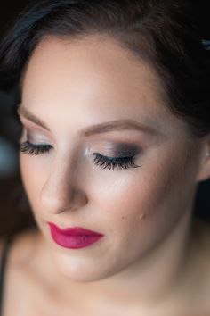 a woman with long eyelashes and red lipstick