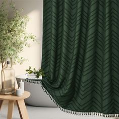 a green shower curtain with tassels hanging from it's side in a bathroom