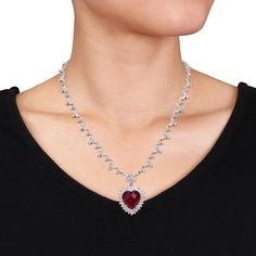 Gorgeously romantic is this trendsetting Red Cubic Zirconia Heart Necklace. Crafted in lustrous sterling silver, this beautiful necklace features 62 marquise-cut, 180 round-cut and two pear-cut shimmering white cubic zirconia gemstones along with one gleaming heart-cut red cubic zirconia gemstone (15 x 15 mm) dangling from the center. Enhanced with a high polish finish, this CZ necklace measures 18-inches long. Gift this distinctive gemstone necklace to your beloved to surprise her. Valentine's Day Formal Cubic Zirconia Necklace, Elegant Heart Cut Ruby Necklaces, Glamorous Heart Cut Jewelry For Valentine's Day, Glamorous Silver Necklace For Valentine's Day, Glamorous Jewelry For Valentine's Day Formal, Glamorous Valentine's Day Jewelry For Formal Occasions, Glamorous Valentine's Day Formal Jewelry, Red Diamond Heart Pendant Jewelry, Red Cubic Zirconia Heart Pendant Jewelry