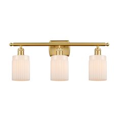 three light bathroom fixture in brass finish with frosted glass shades and gold metal fittings